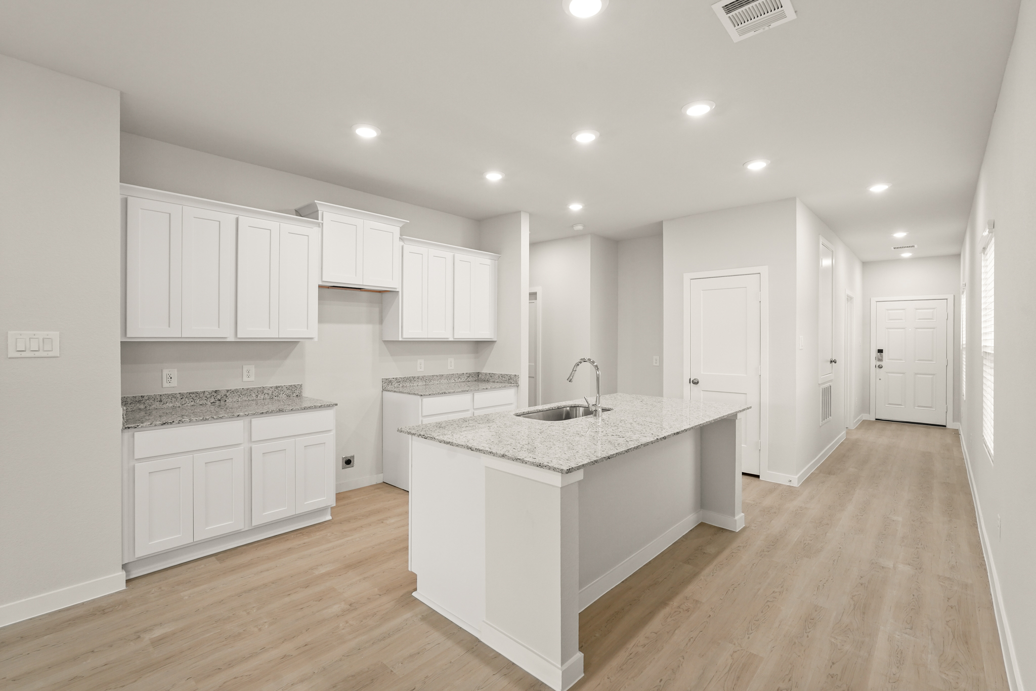 A kitchen with white cabinets.