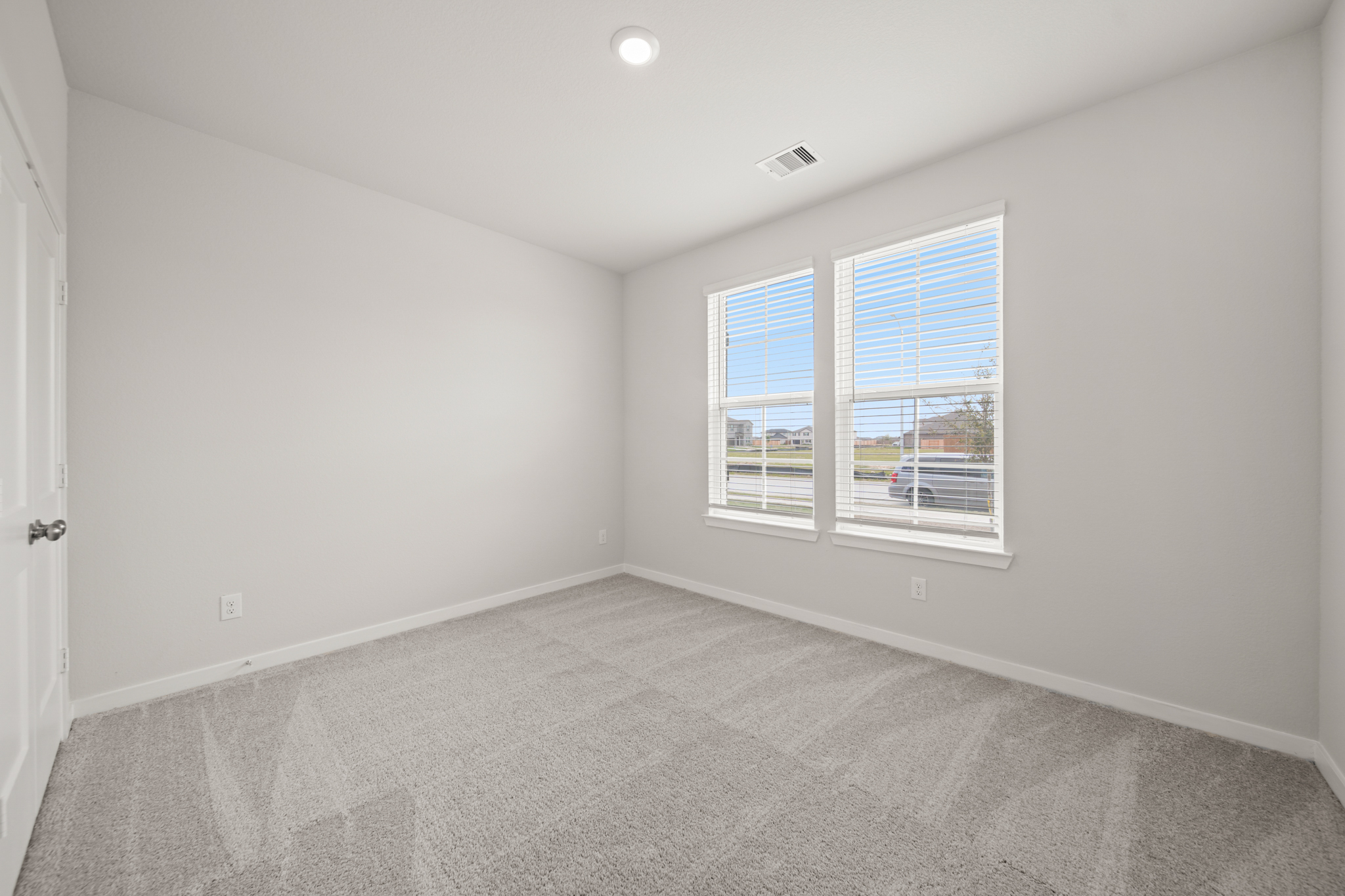 A room with a window and a carpet.