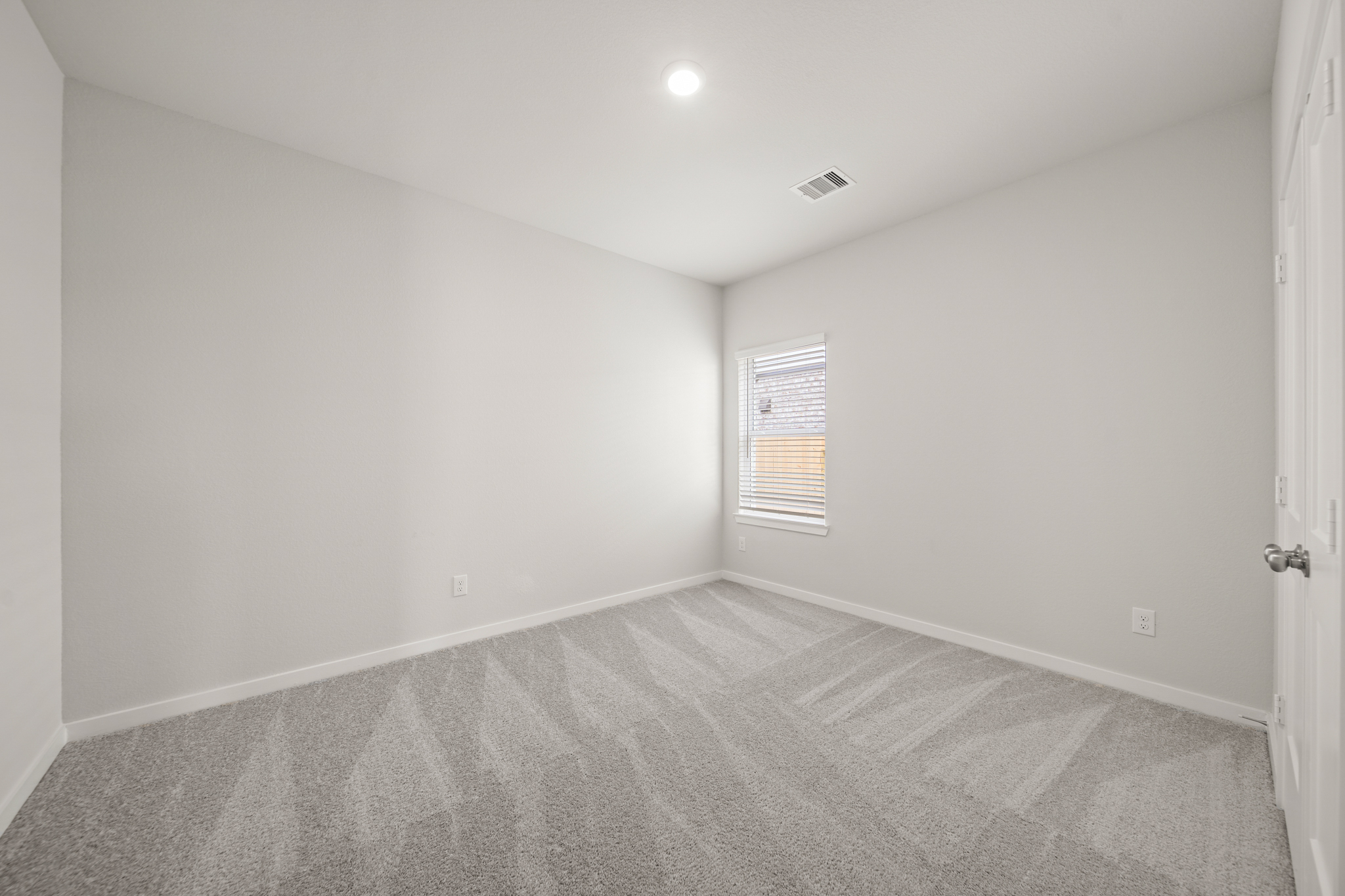 A room with a carpet and a door.
