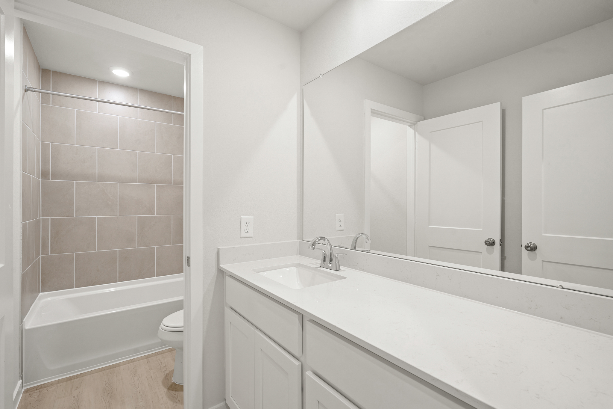 A bathroom with a tub sink and toilet.
