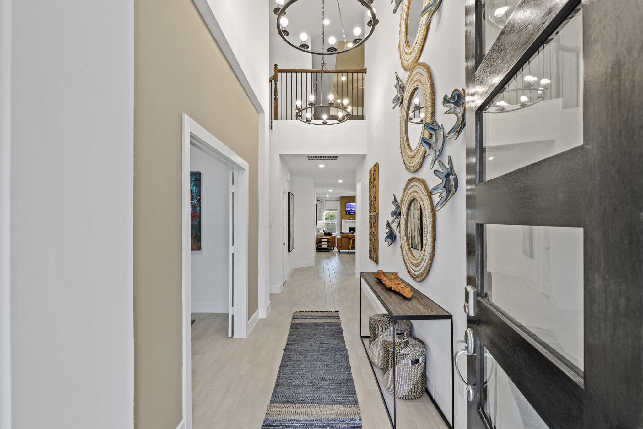 A hallway with a desk and mirror.