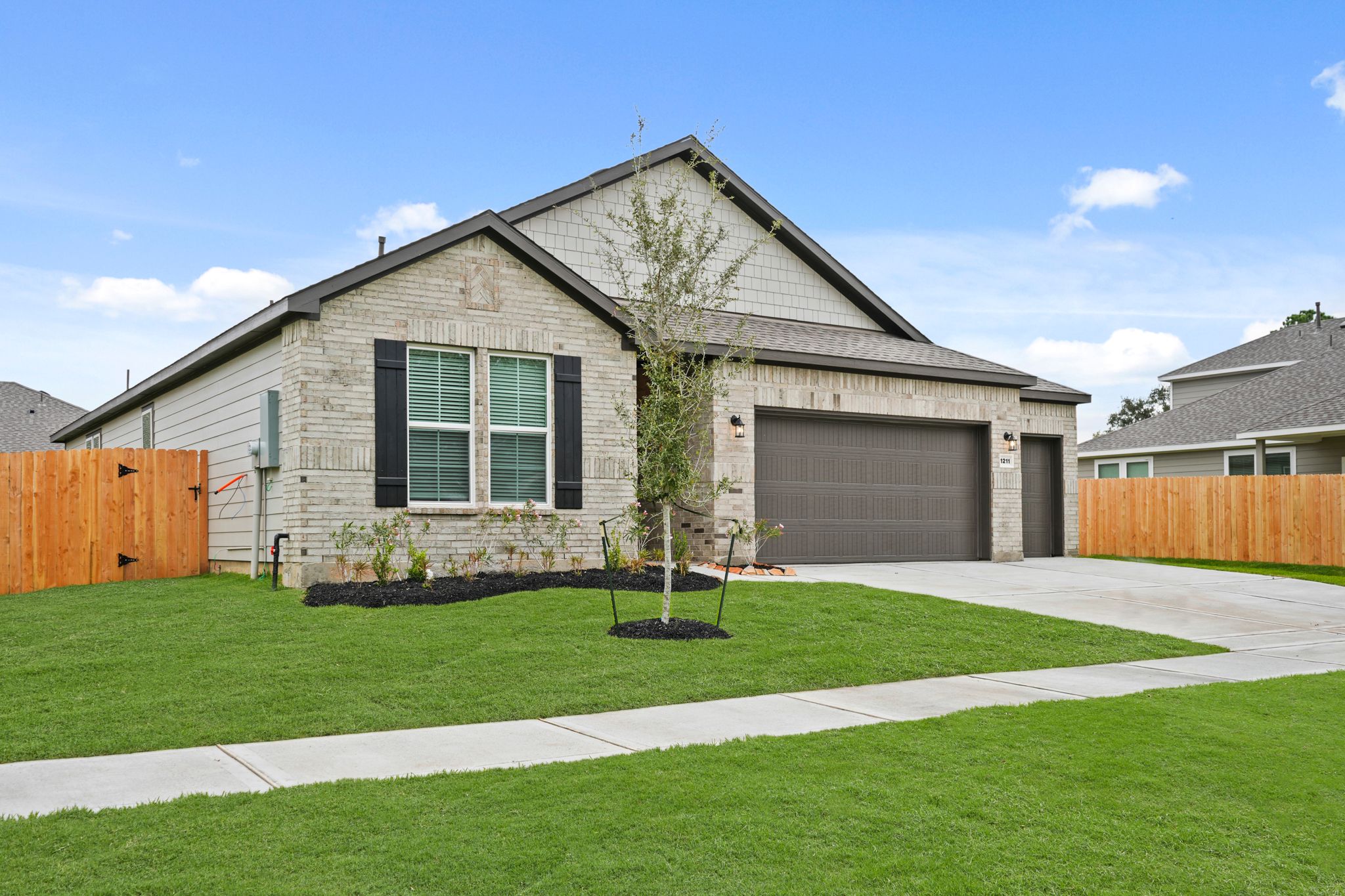 A house with a tree in the front yard.