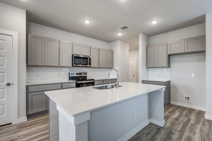 A kitchen with white cabinets.