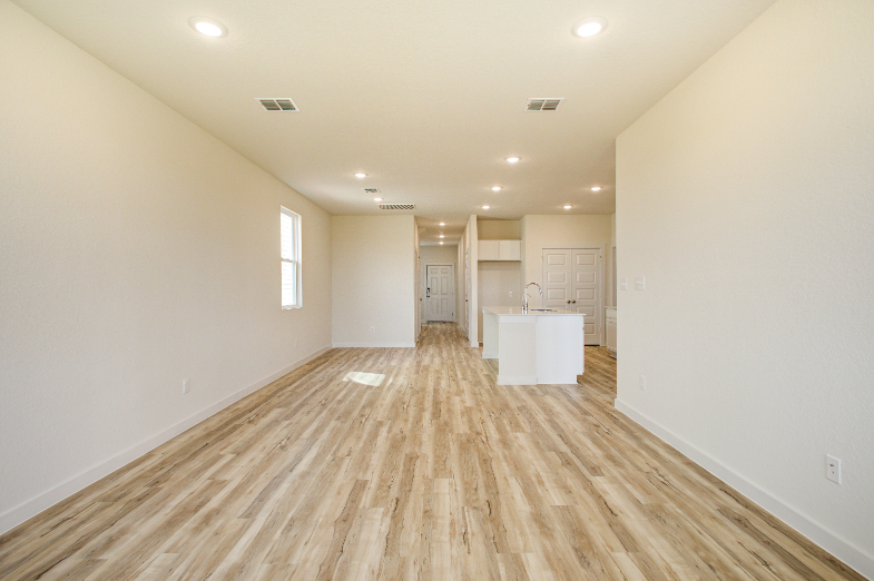 A room with white walls and wood floors.
