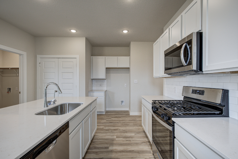 A kitchen with white cabinets.