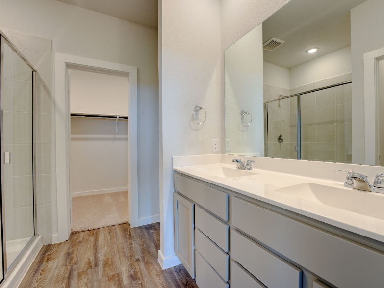 A bathroom with a sink and a shower unit.