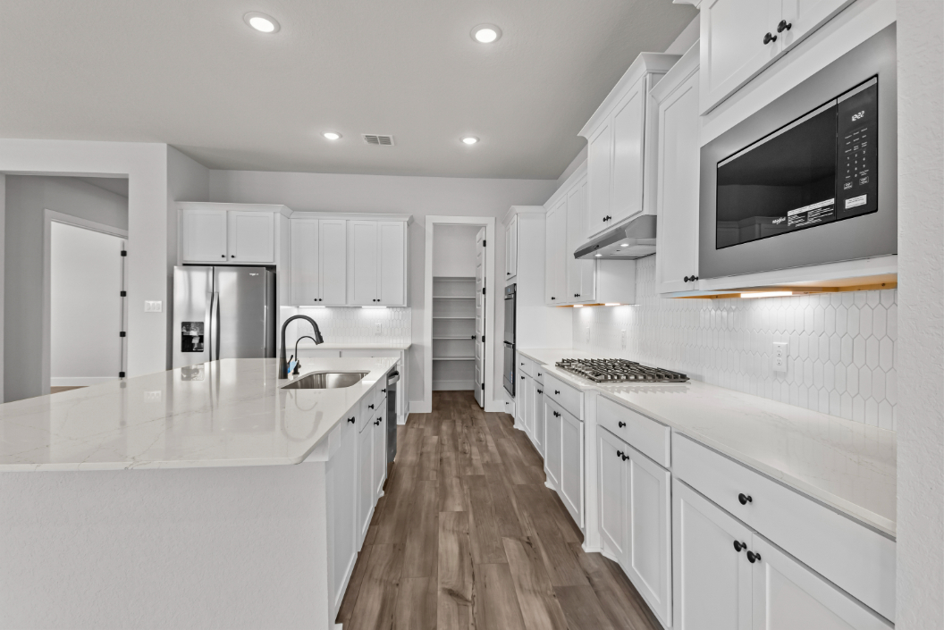 A kitchen with white cabinets.