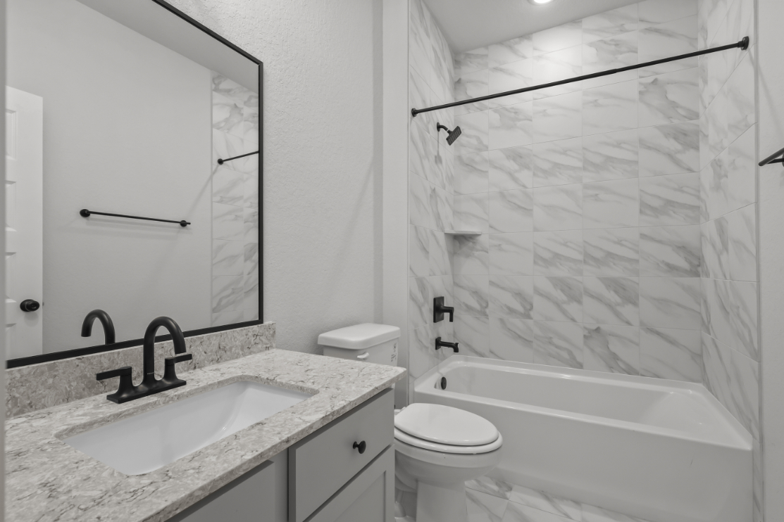 A bathroom with a shower and sink.