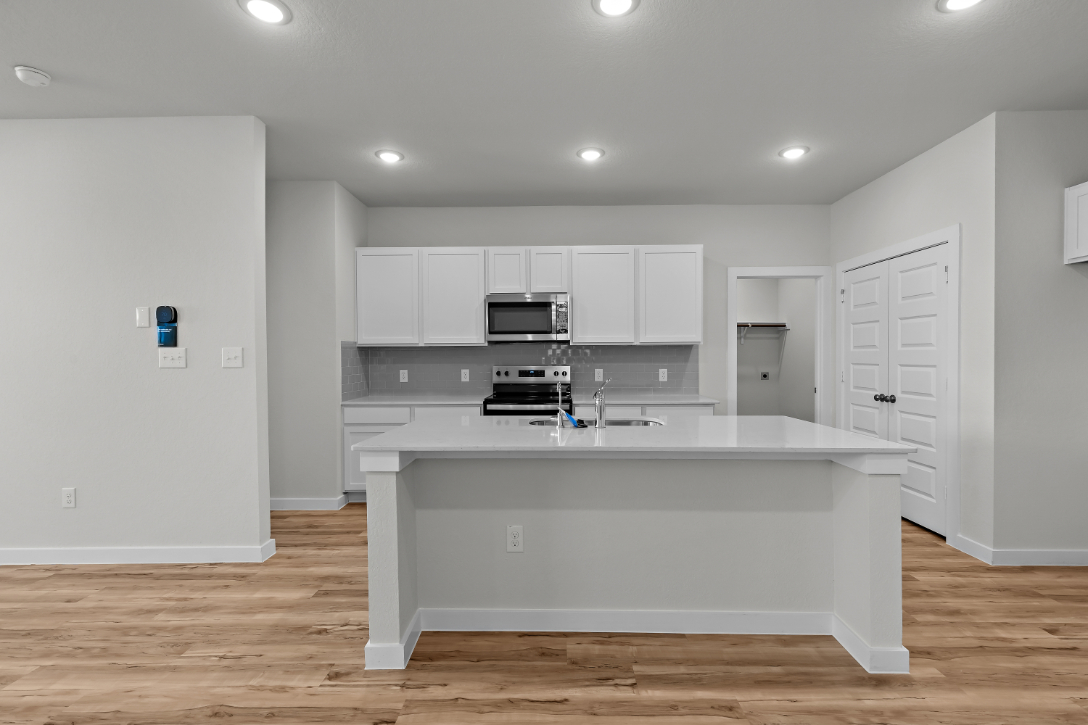 A kitchen with white cabinets.