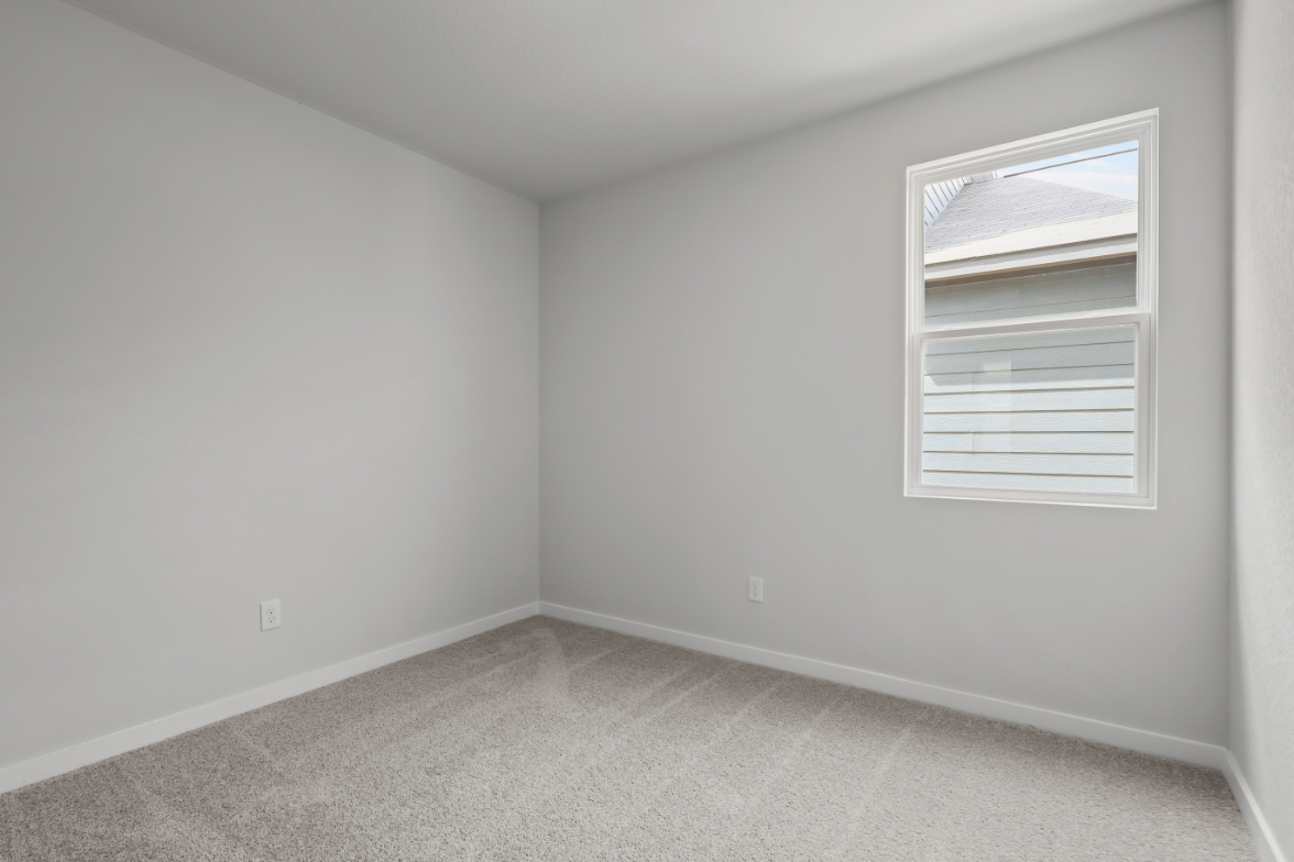 A room with a window and a carpet.