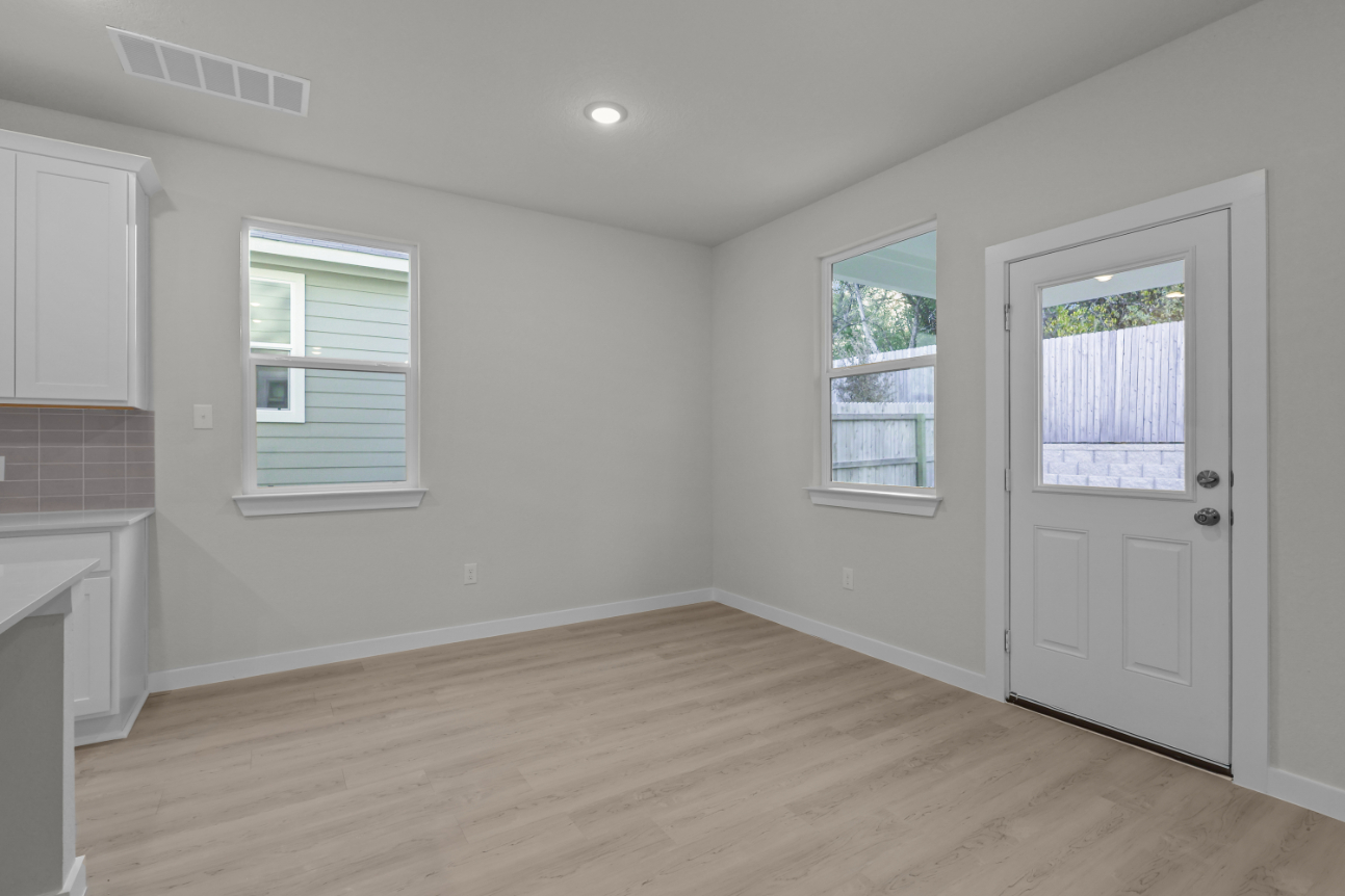 A room with a wood floor and white walls.