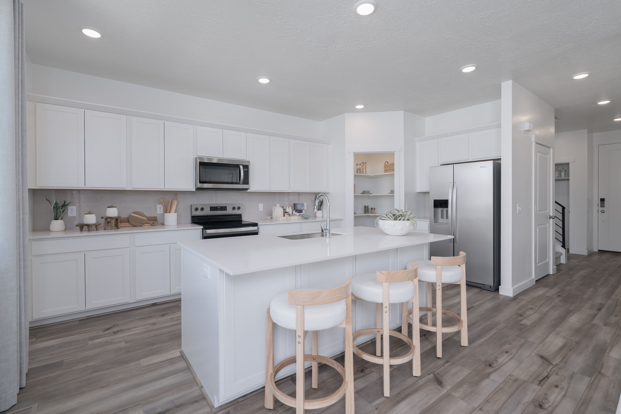 A kitchen with white cabinets.