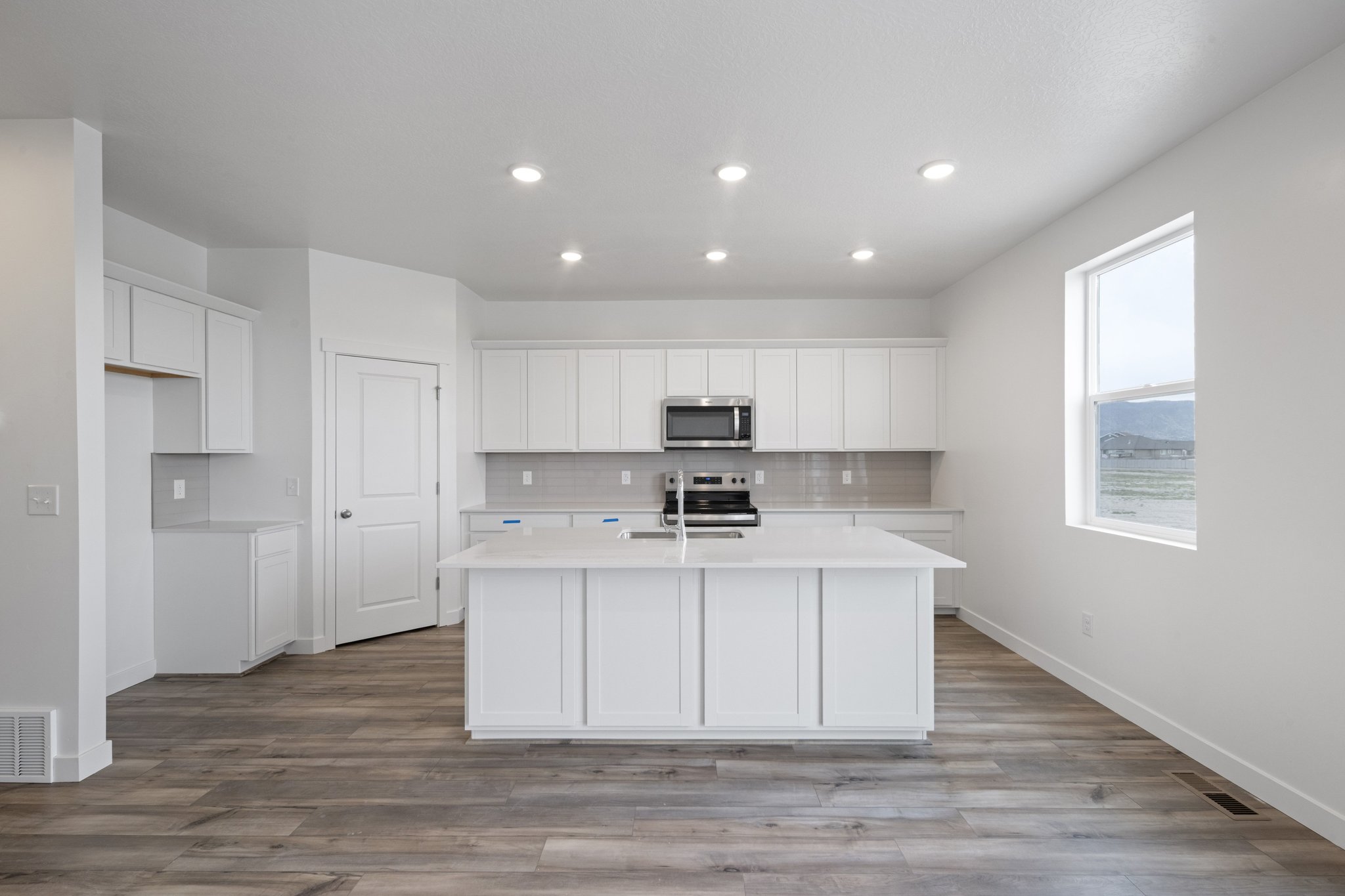 A kitchen with white cabinets.
