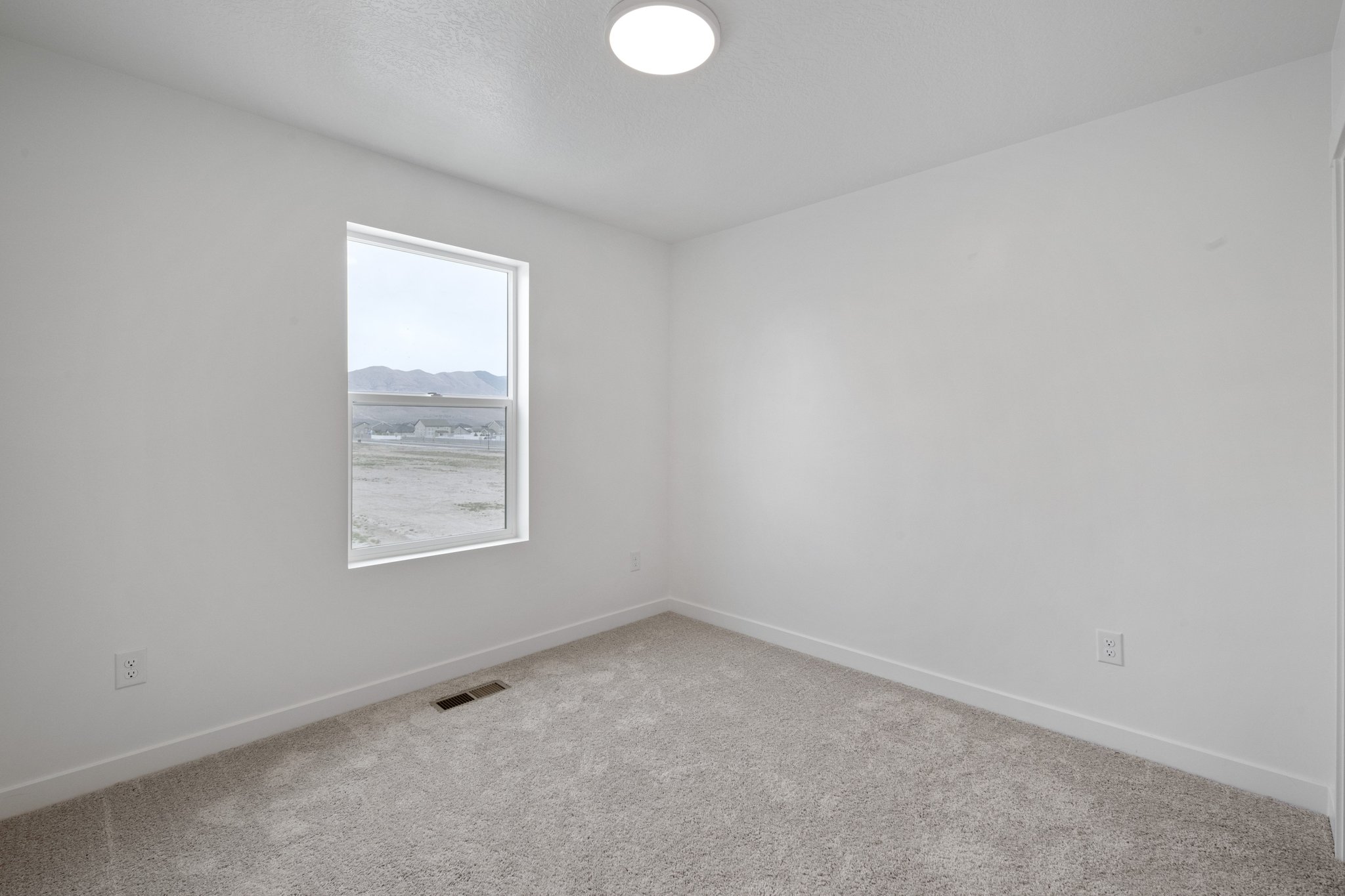 A room with a window and a carpet.