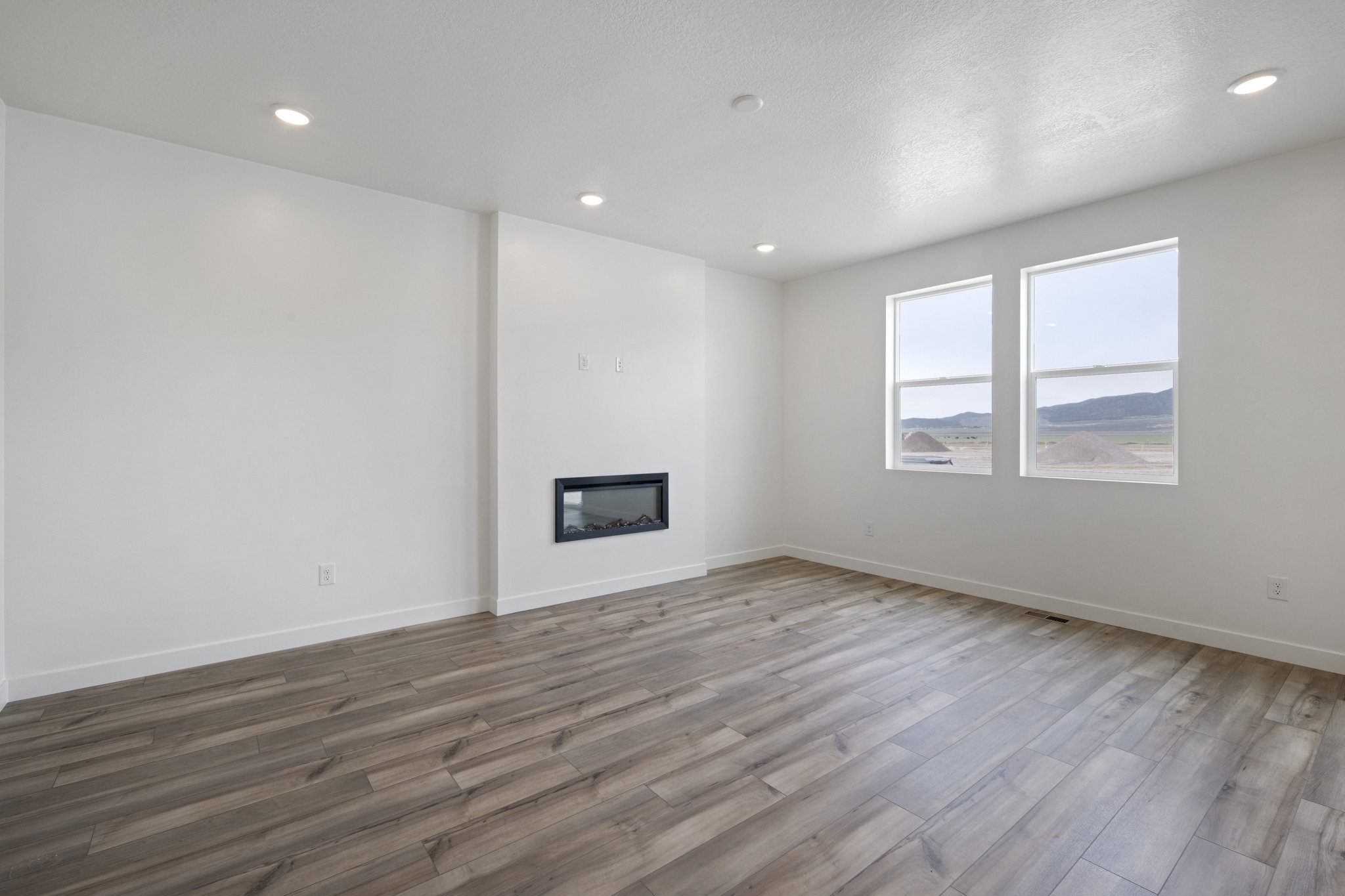 A room with a wood floor and a wood floor with a painting on the wall.