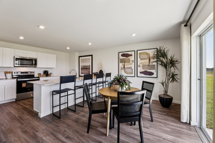 A kitchen with a dining table and chairs.