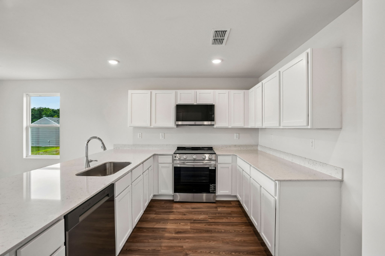 A kitchen with white cabinets.