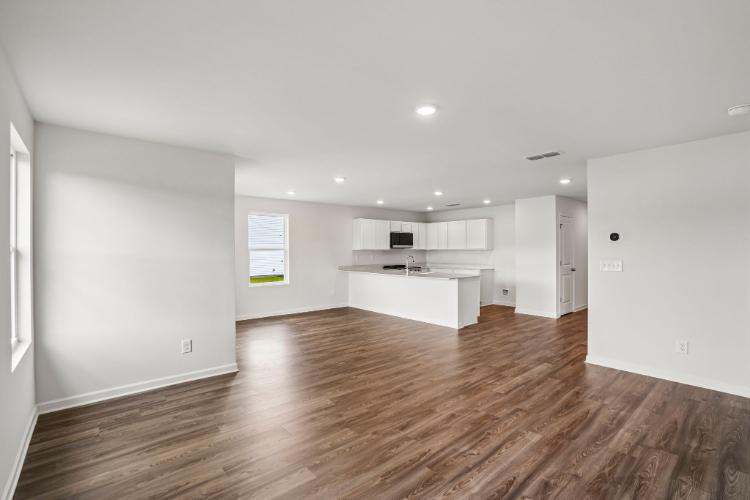 A room with white walls and wood floors.