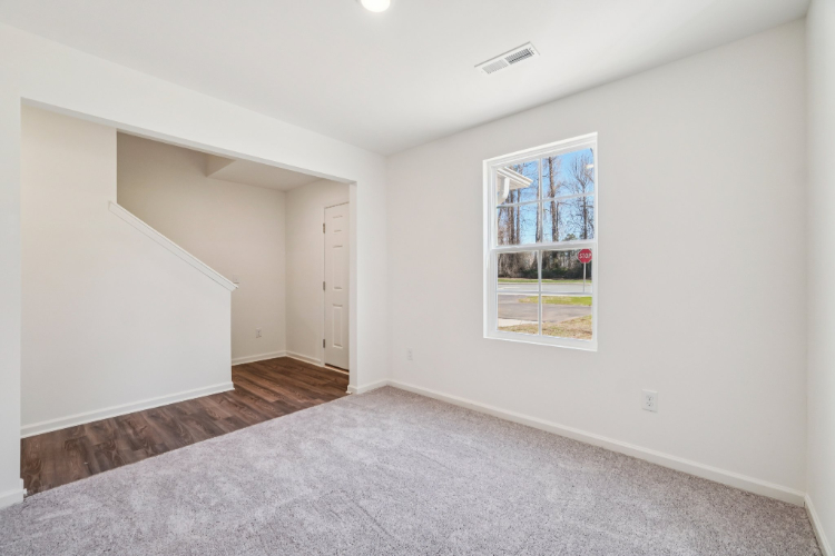 A room with a window and a rug.