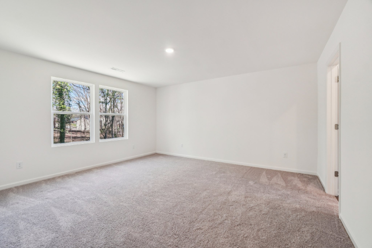 A room with a carpet and a window.