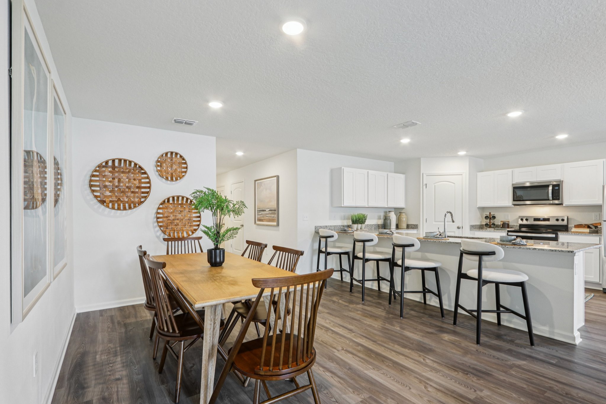 A kitchen with a dining table and chairs.