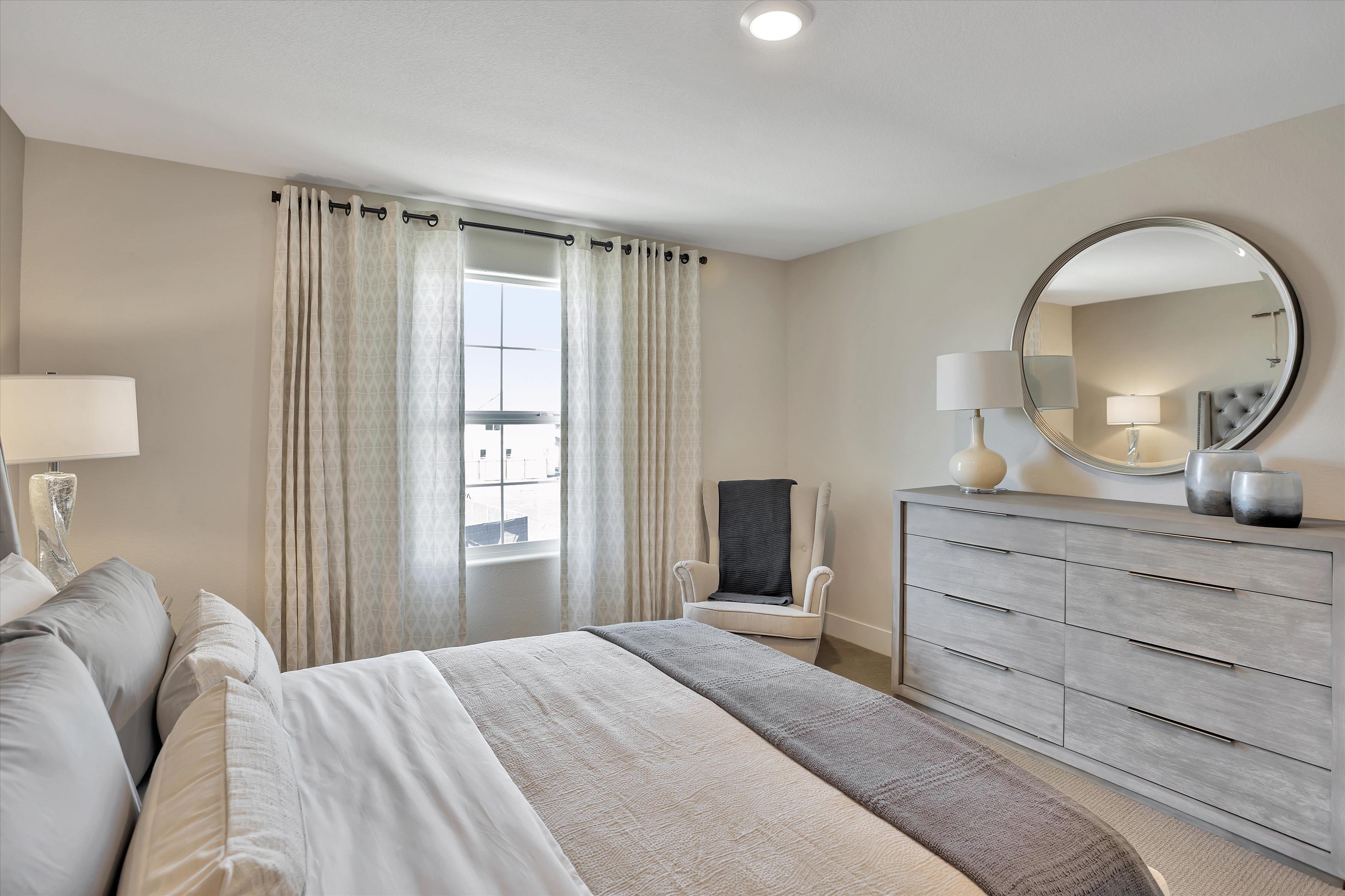 A bedroom with a large mirror.